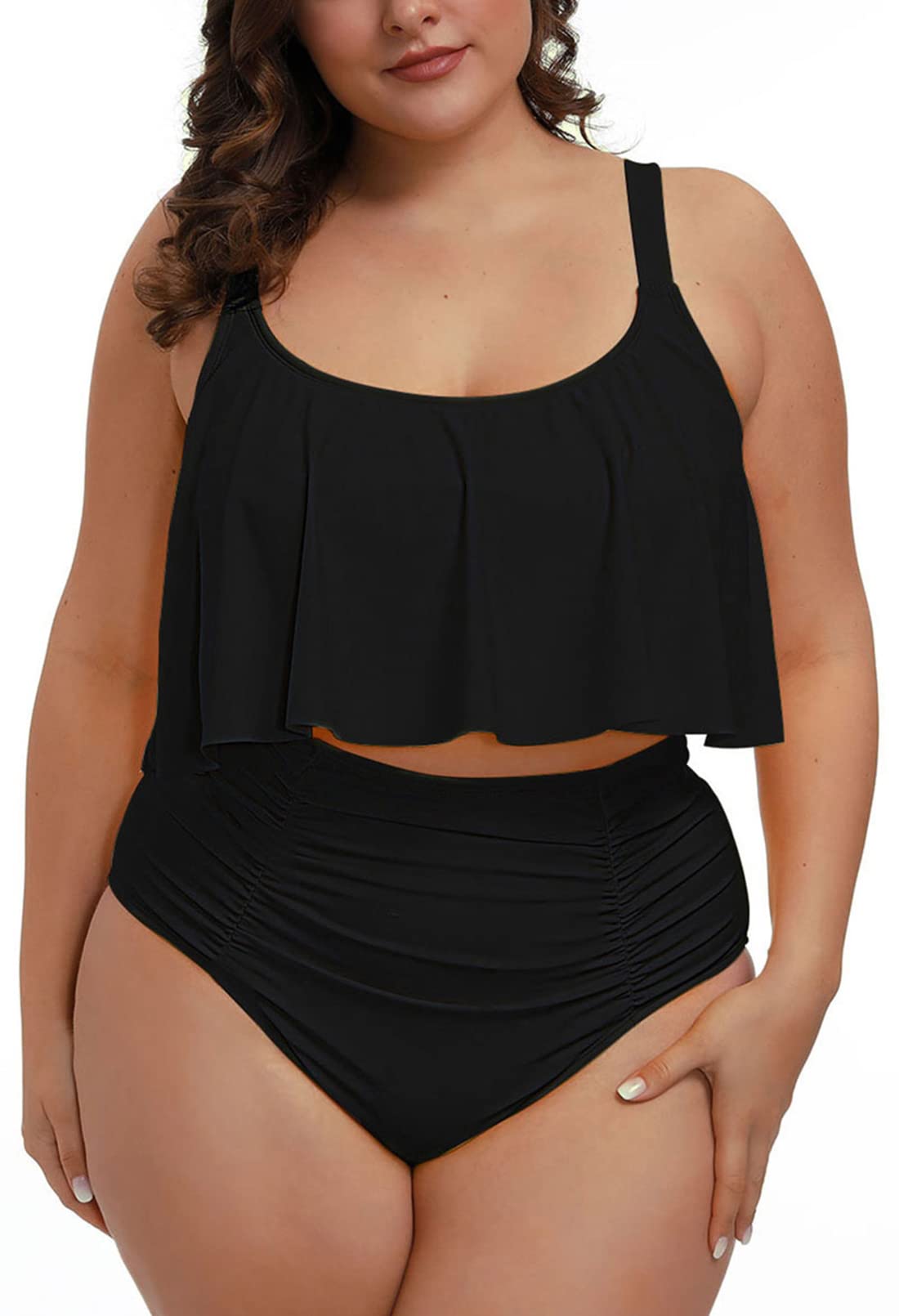 Modell bär svart tankini med volangöverdel och högmidjad, rynkad underdel.