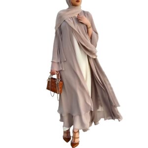Modell i lång beige öppen abaya med draperad halsduk och handväska.