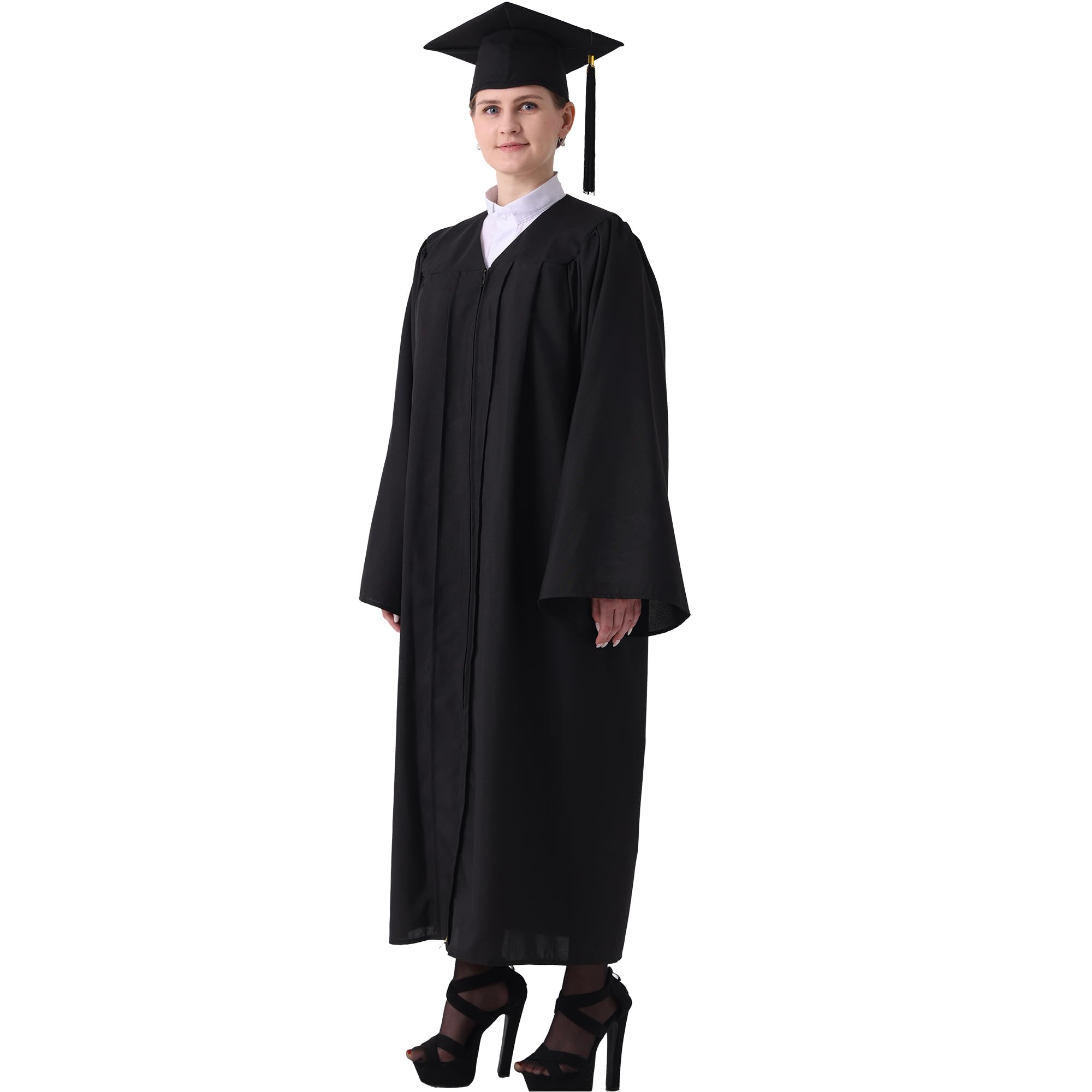 Person i svart examensdräkt med mössa och tofs, stående mot vit bakgrund.
