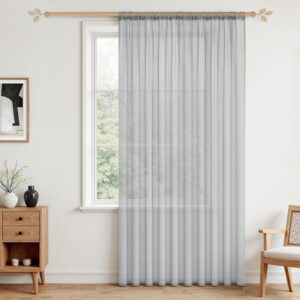 Halvtransparent grå gardin hängd framför ett fönster i ett ljust rum.