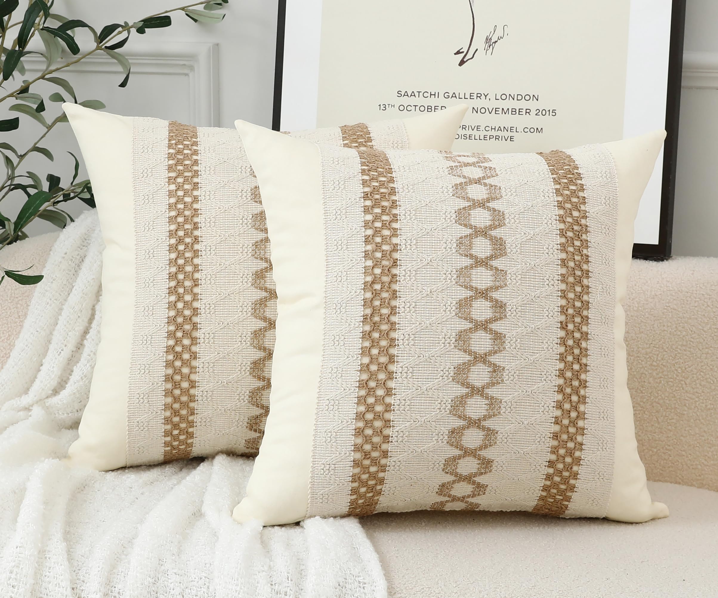 Två vävda kuddfodral med rutmönster i beige och naturvit färg, placerade i en soffa.