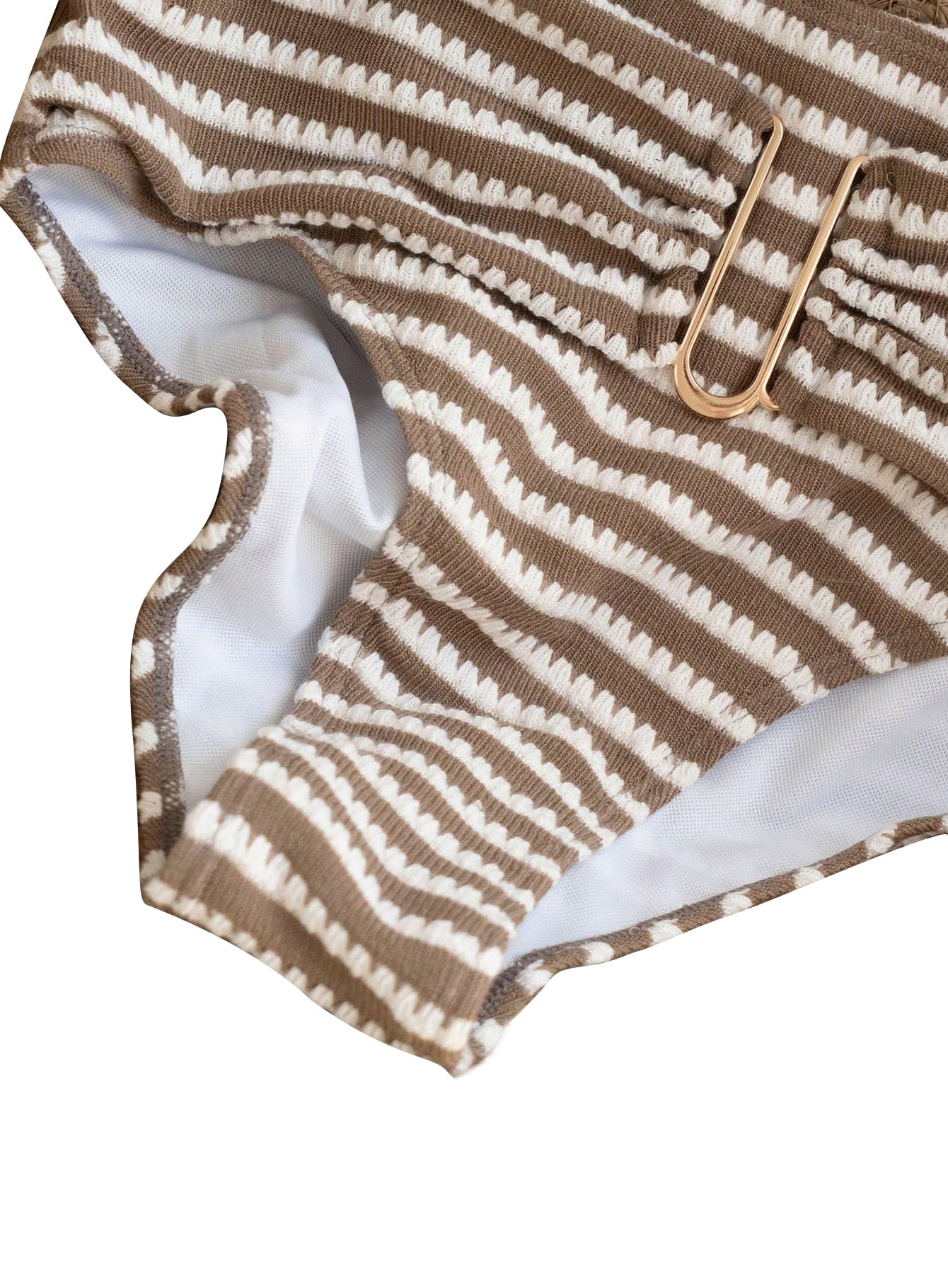 Närbild av brun- och vitrandig bikinitrosa med guldfärgad metalldetalj.