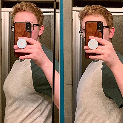 Person fotograferar sig i spegeln iförd en ljus topp med mörka ärmar.