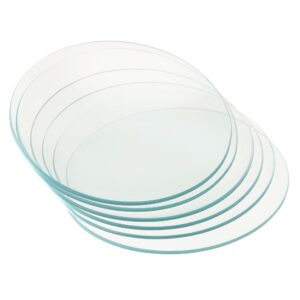 Flera runda, transparenta glasskivor med släta, fasade kanter i överlappande hög.