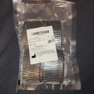 Förpackad hårkam med klämfunktion, synlig genom en genomskinlig påse.