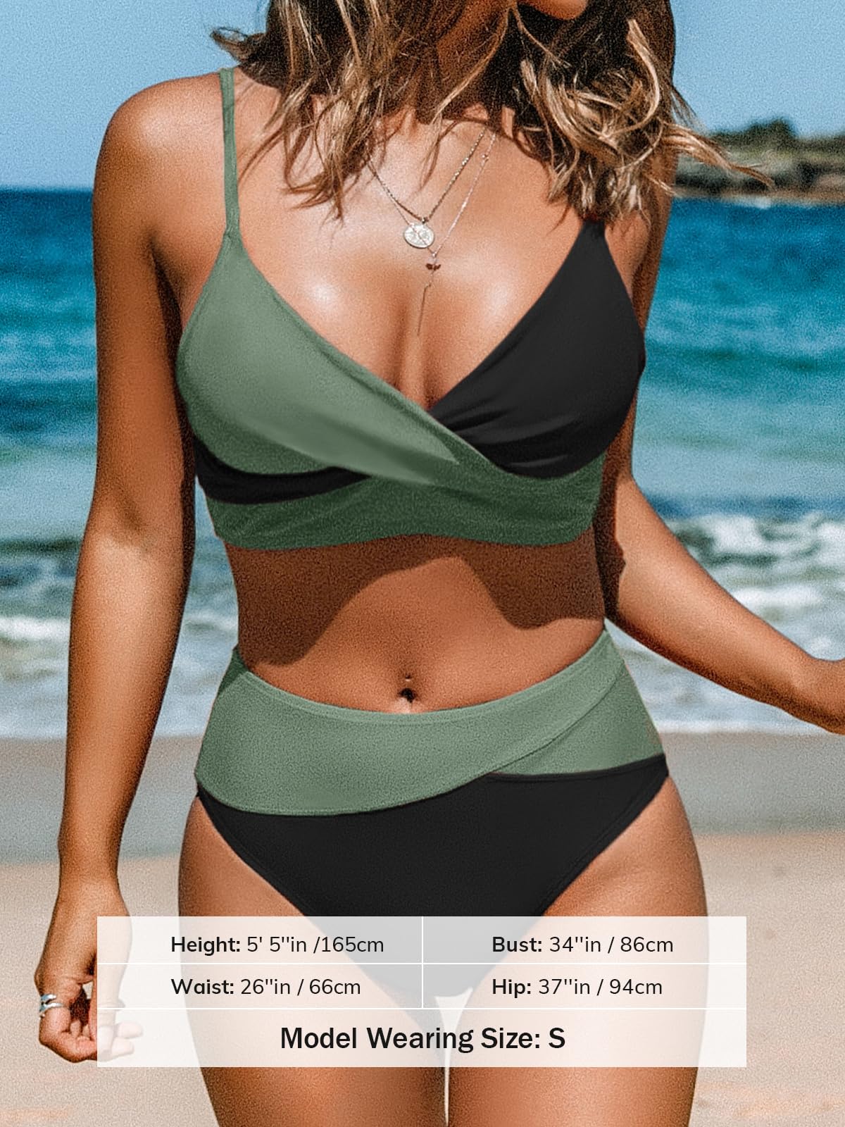 Modell bär en svart och grön bikini med omlottöverdel och hög midja vid stranden