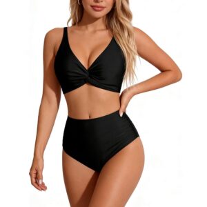Modell bär svart bikini med vriden överdel och högmidjad underdel.