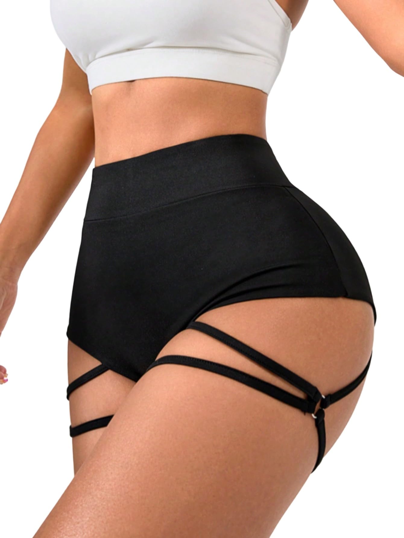 Svarta högmidjade shorts med korsade remmar på en modell.