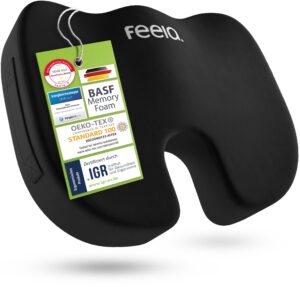 Svart ergonomisk sittkudde med U-format hål och hängande certifieringsetikett.