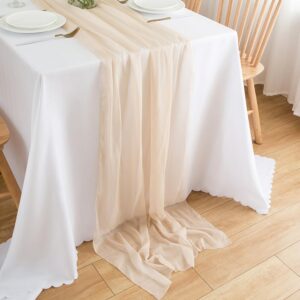 Beige chiffonglöpare draperad över ett dukat bord med längder ned mot golvet.