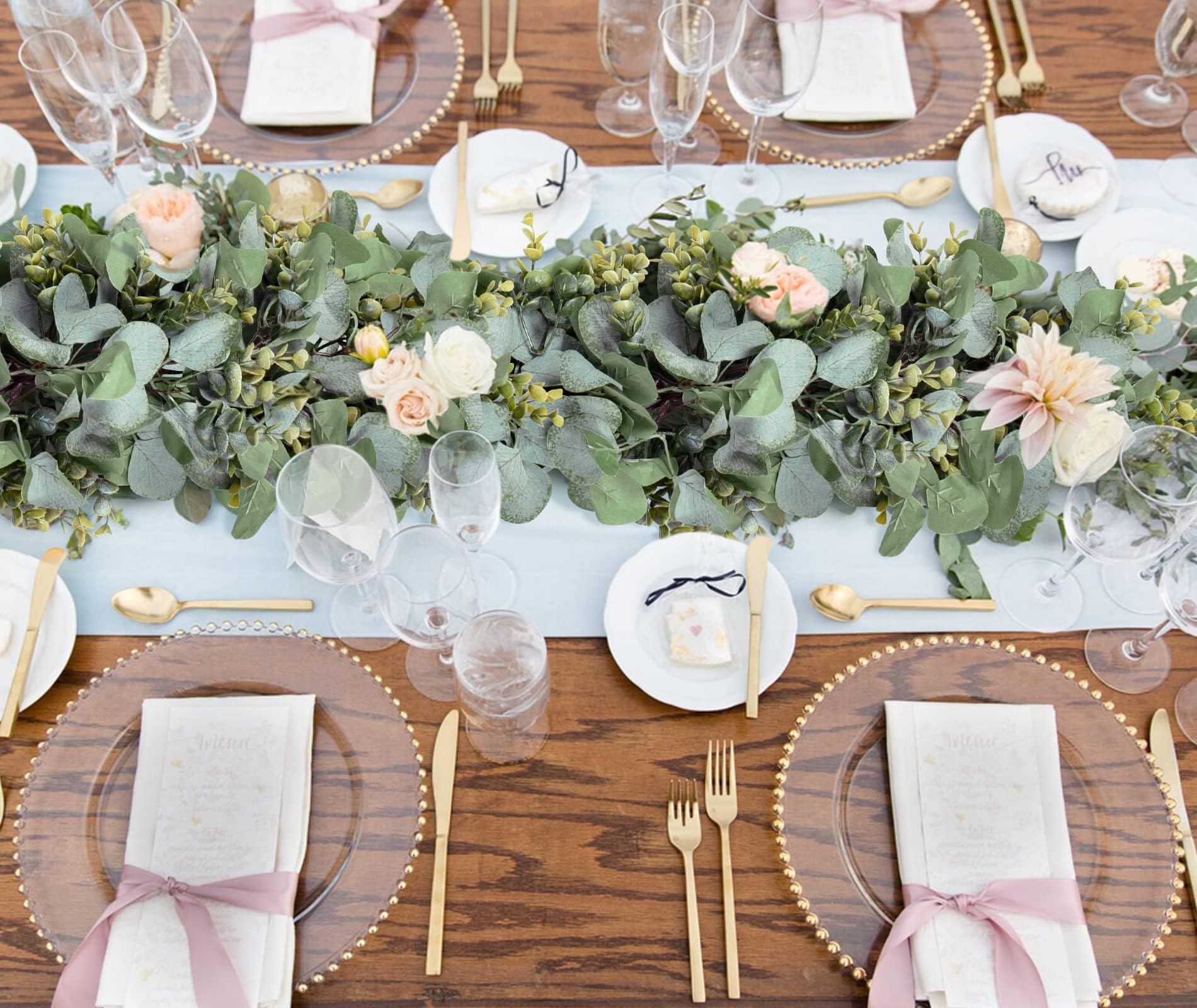 Eukalyptusgirlang med blommor som bordsdekoration på ett festdukat bord
