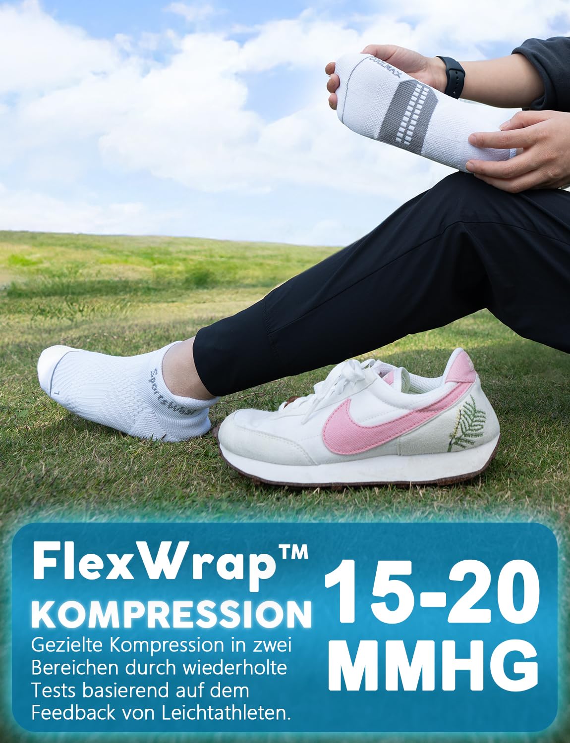 Person i svarta byxor tar på sig en vit kompressionsstrumpa, med en vit sneaker bredvid.