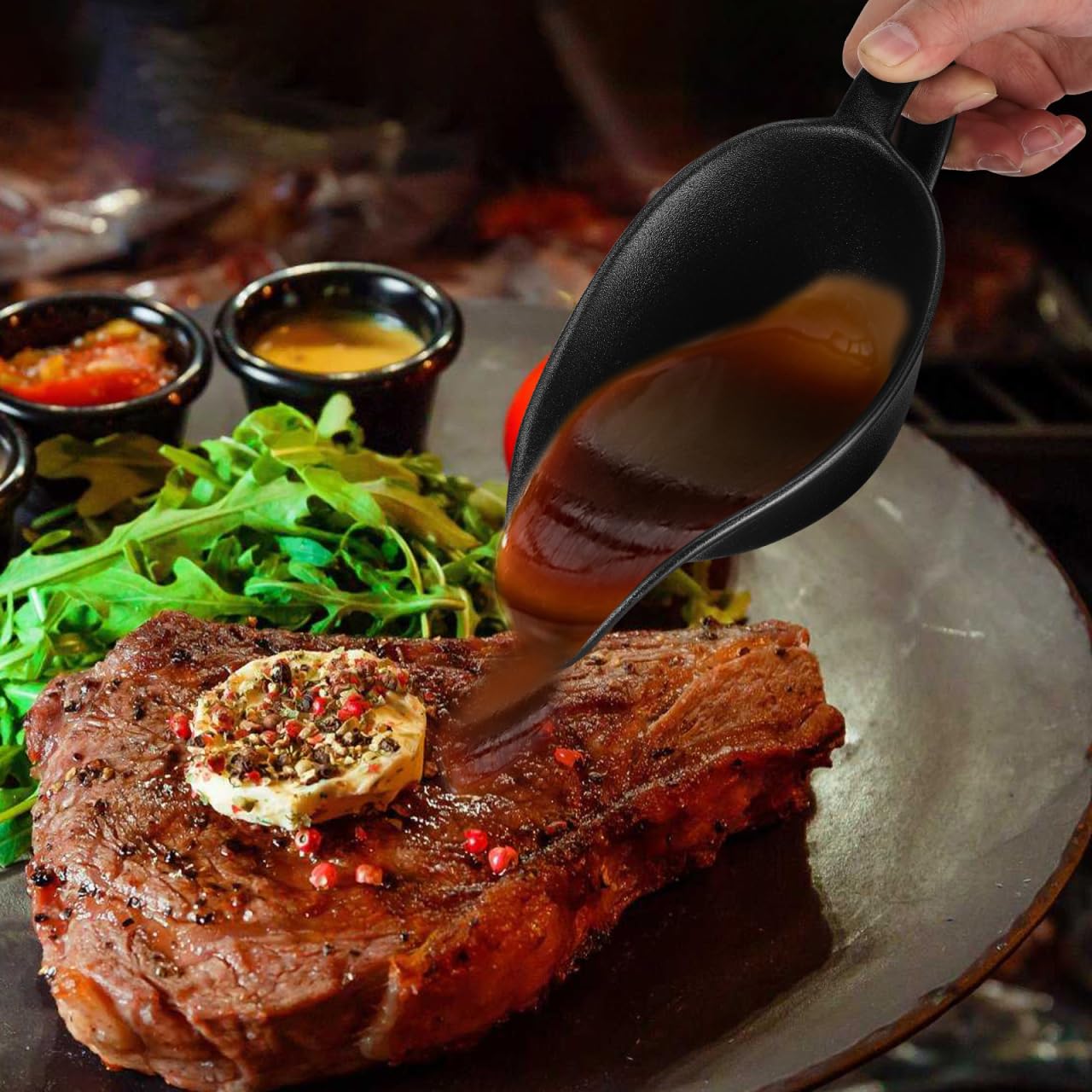 Svart såsskål med handtag häller sås över en grillad köttbit.